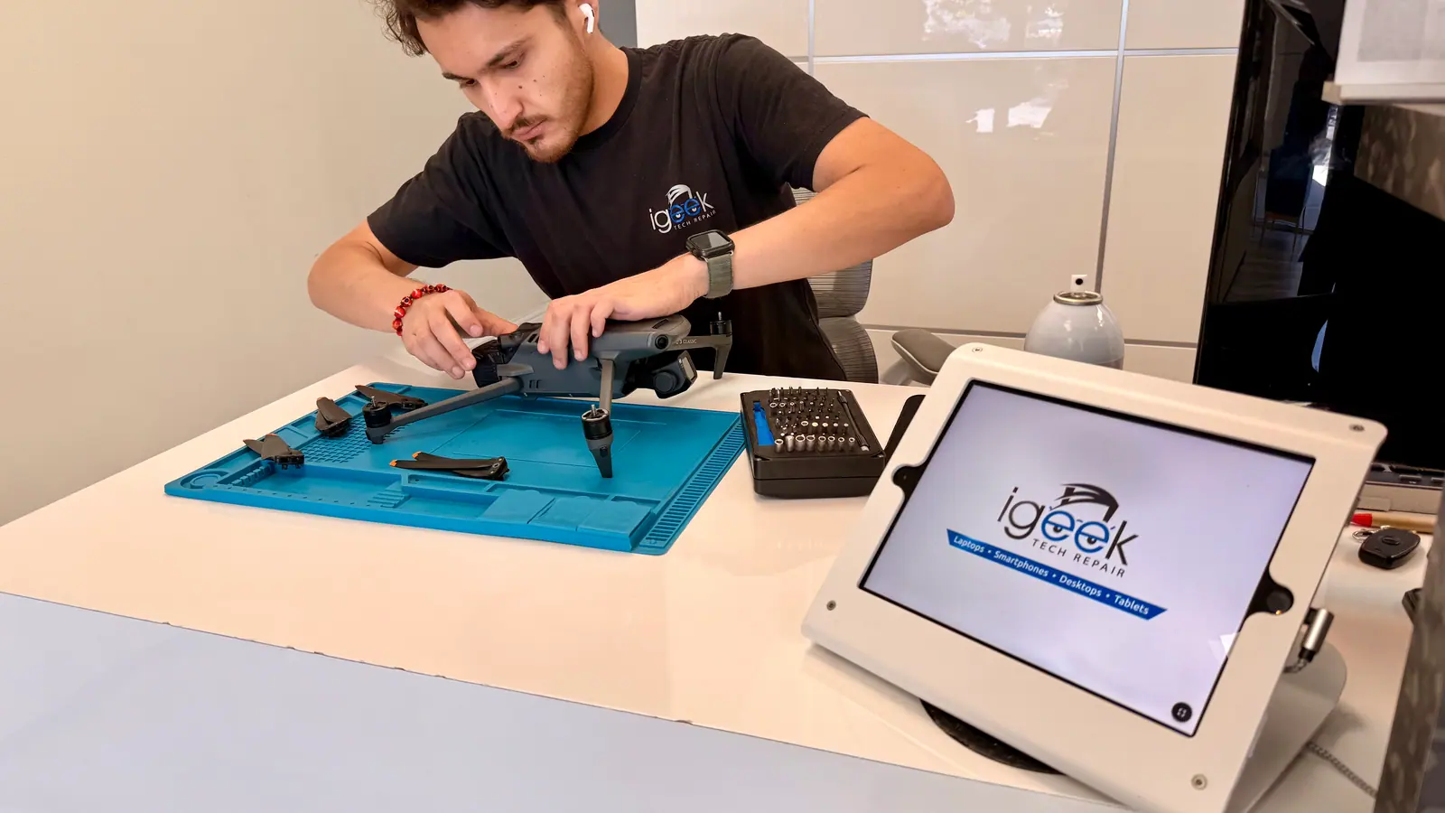 Technician working on a folding drone at the front counter
