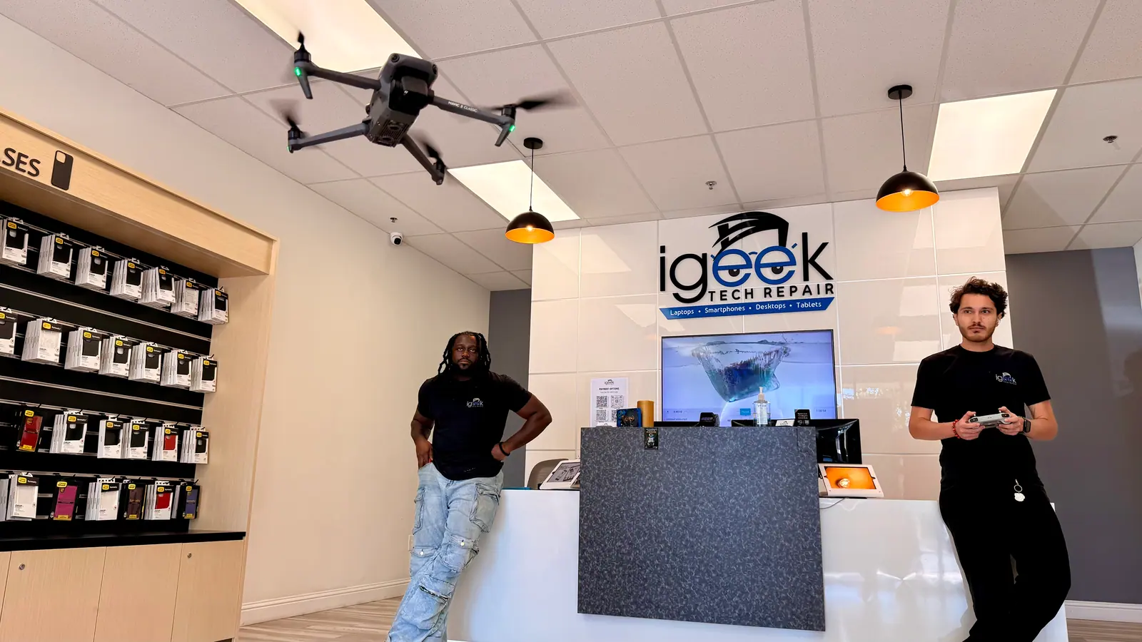 iGeek technicians at the front counter under the iGeek Tech Repair sign